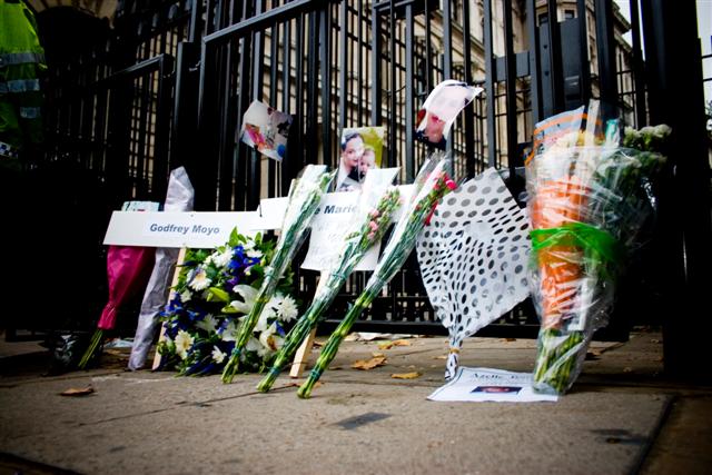 floral tributes near the gate outside a building