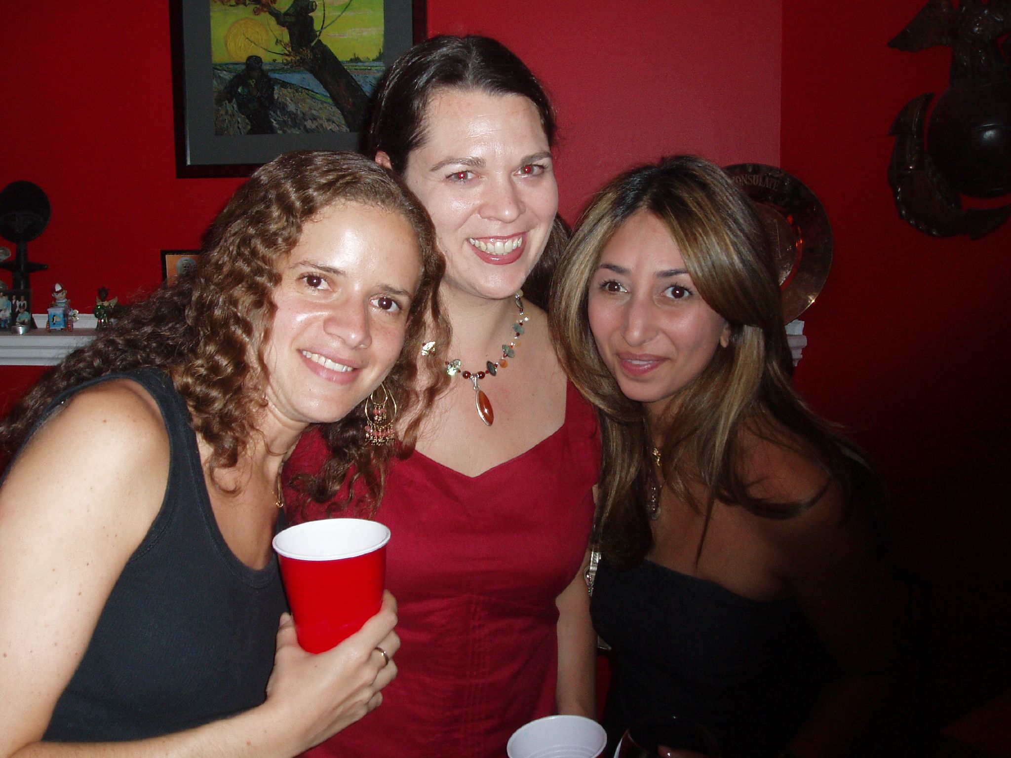 two women and a woman with drinks are posing for the camera