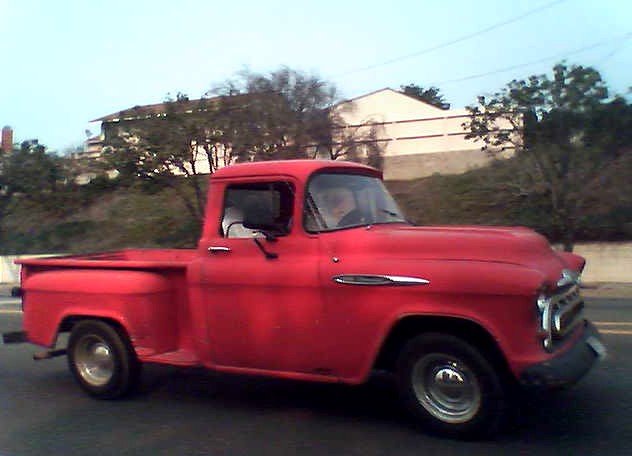 a red truck traveling down a city street