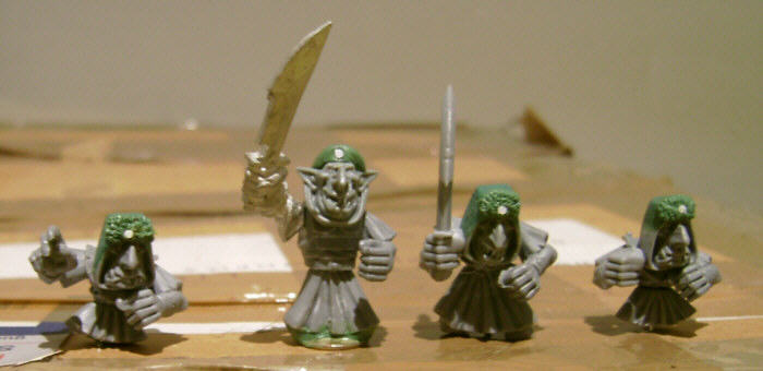 several toy soldiers in white and green outfits with a knife
