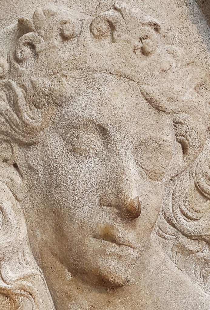 an old sculpture depicting a woman's face and hair