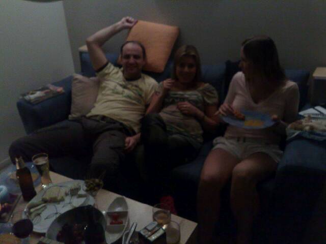 a man and two women sitting on top of a couch