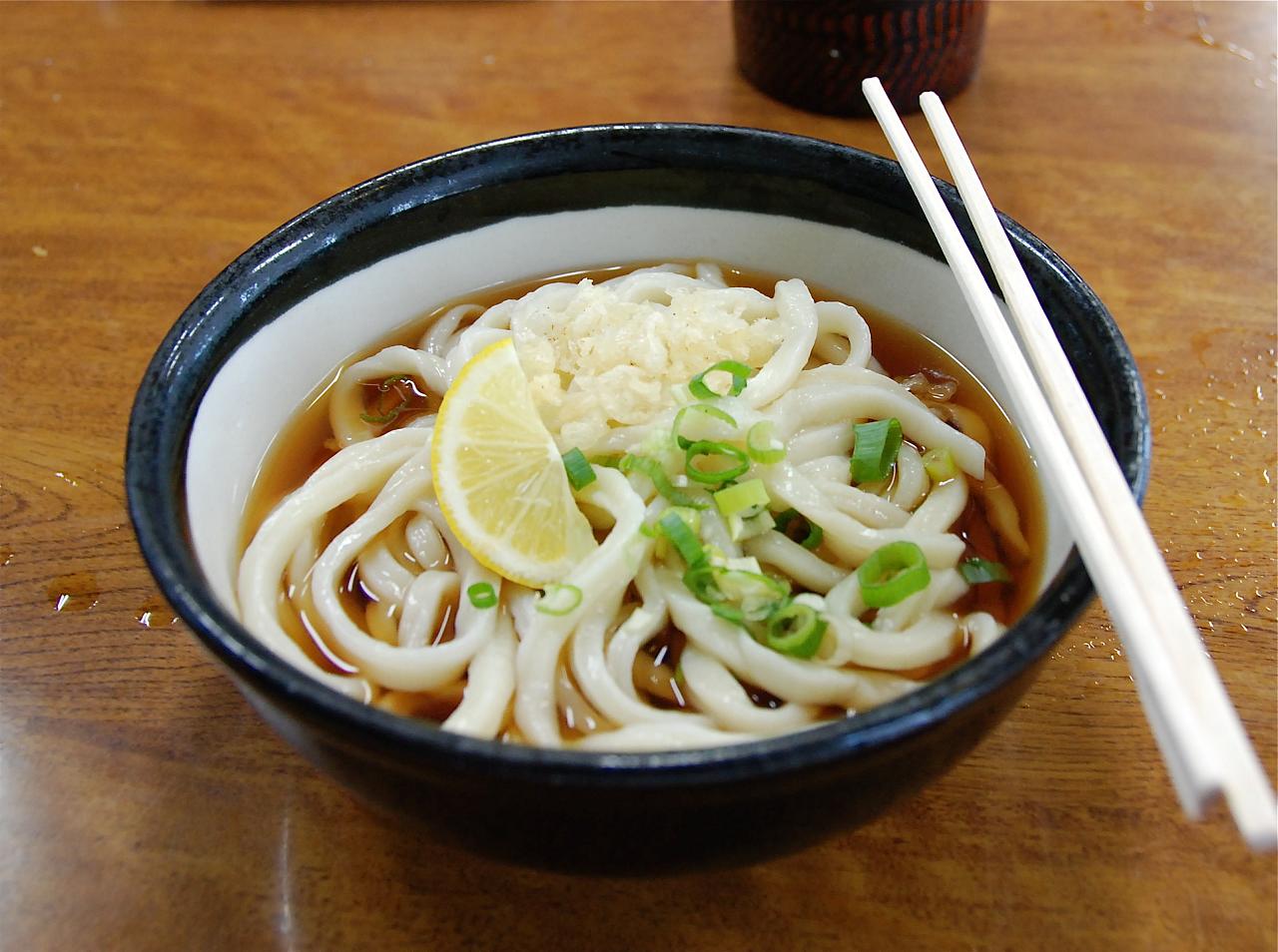 a bowl of noodle soup with some chop sticks