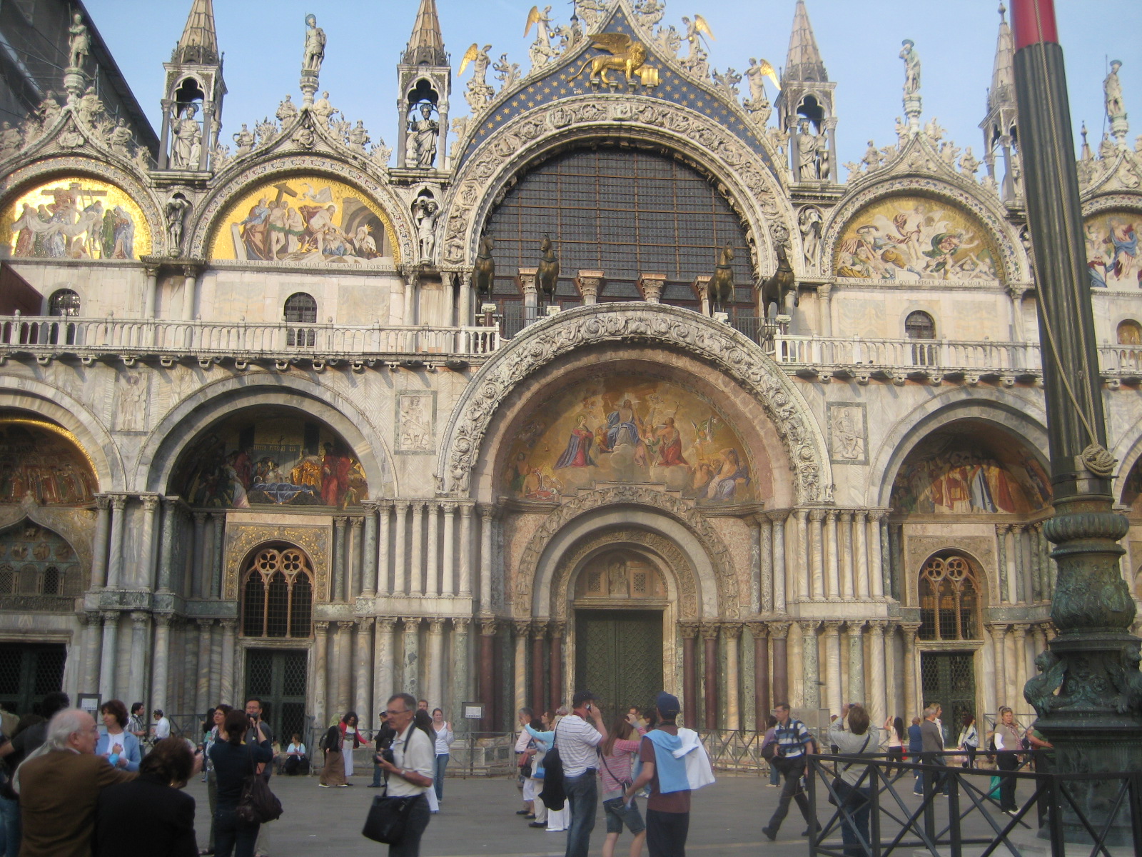 people outside an ornate building with many details