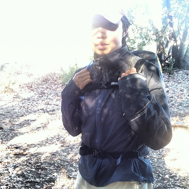 a man in hiking gear stands near some rocks