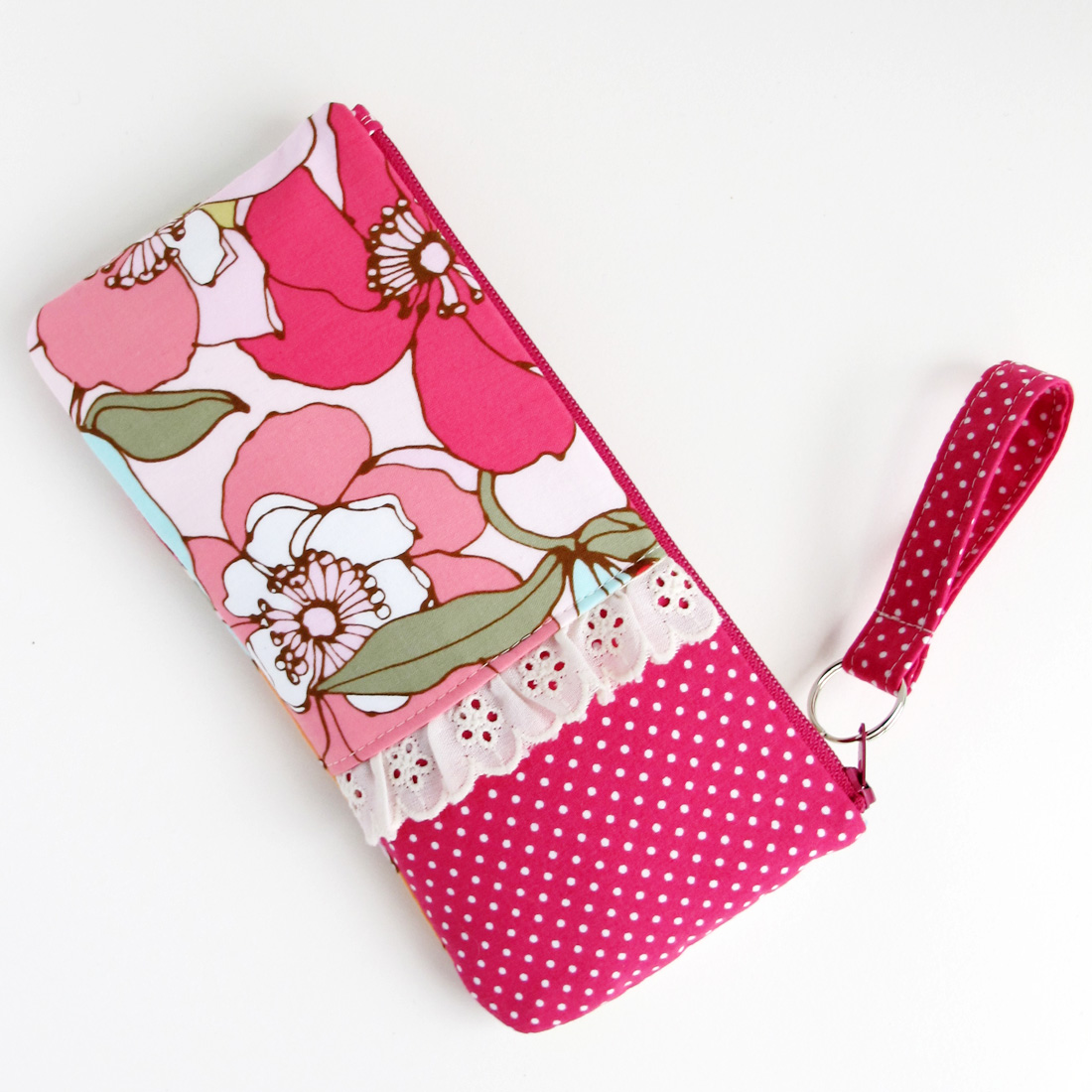 there is a pink and white polka dot wallet with flowers on it