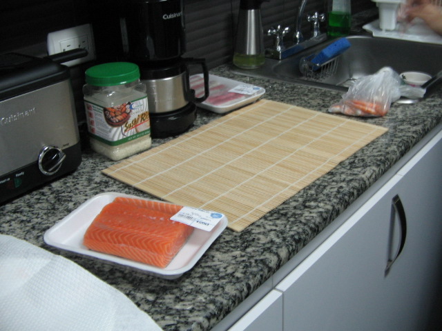 two pieces of salmon sitting on top of a  board