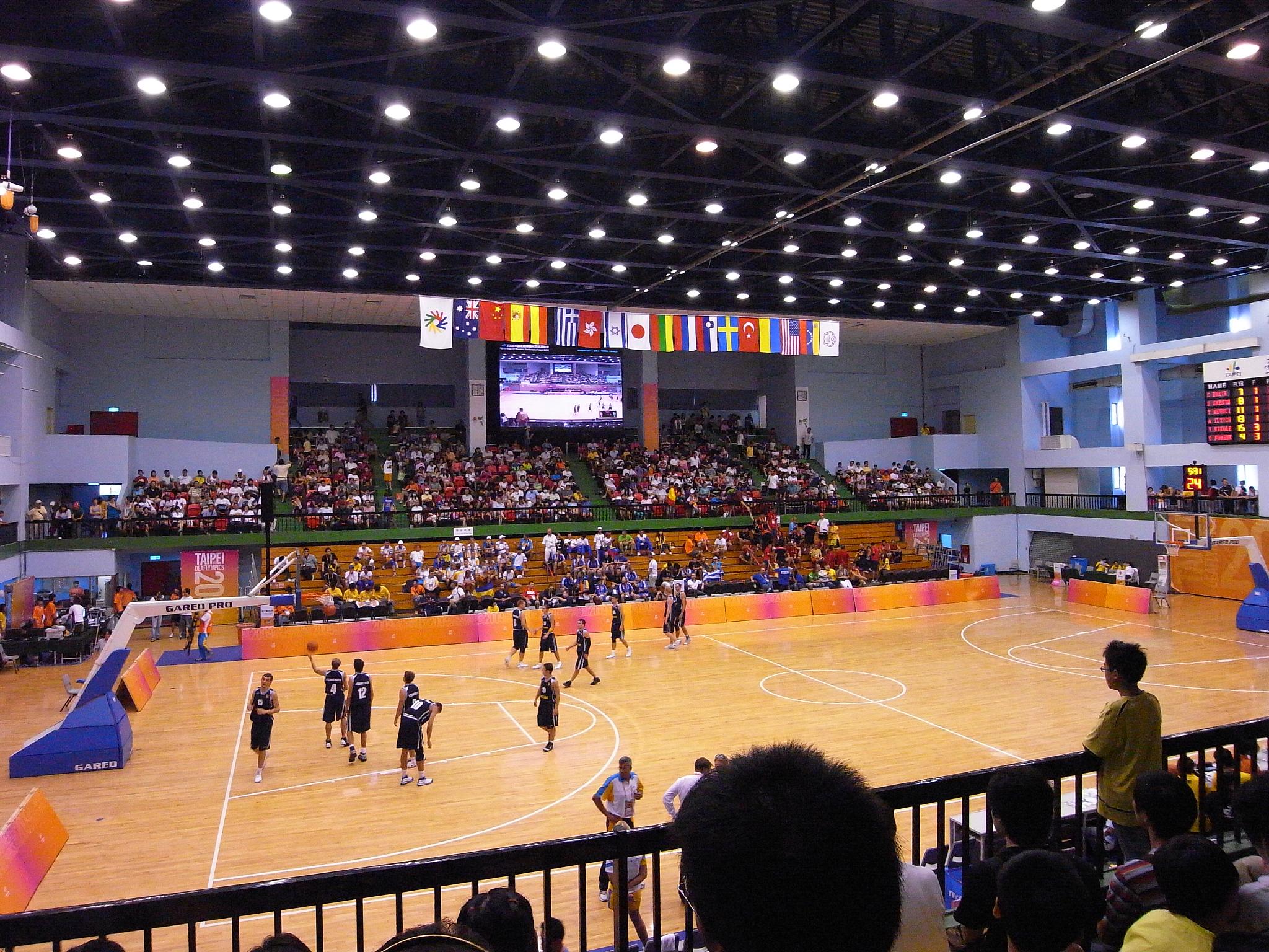 a gymnasium full of people in front of a television screen