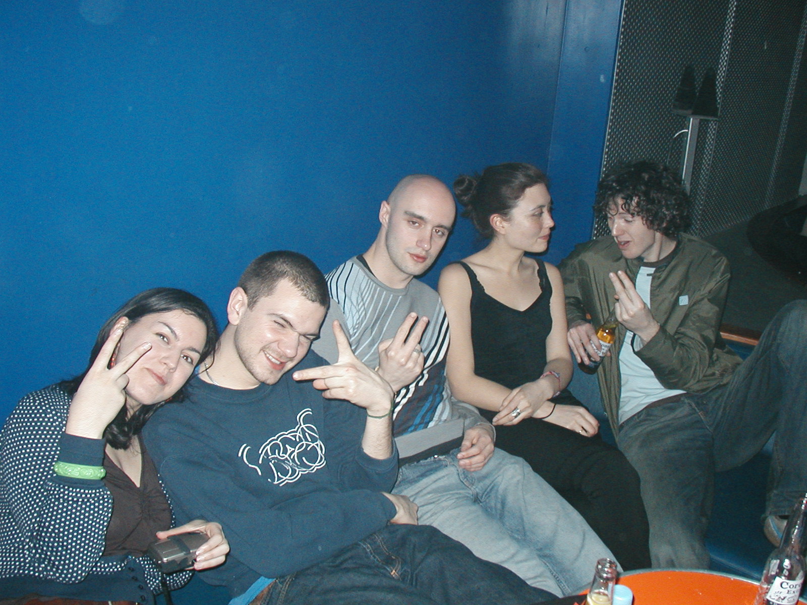 a group of people sitting in front of a blue wall