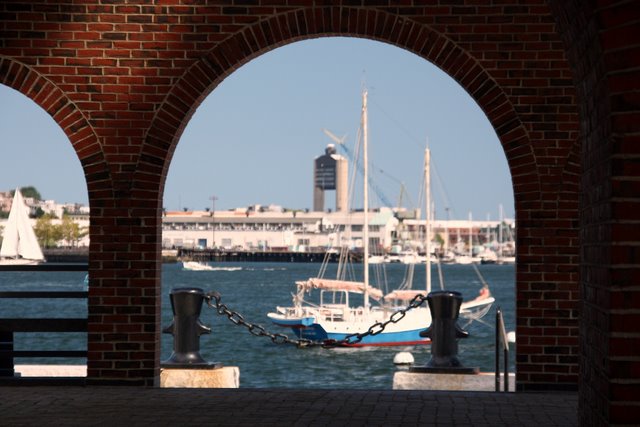 two white boats docked in front of a brick wall