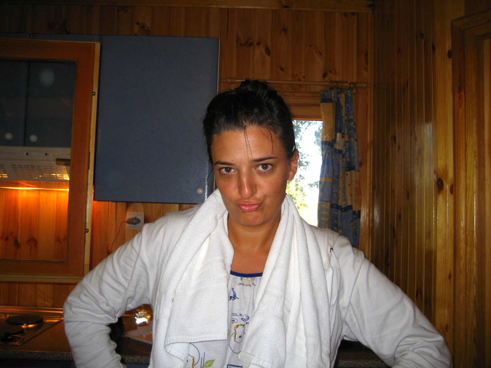 a woman standing next to a kitchen counter covered in towels