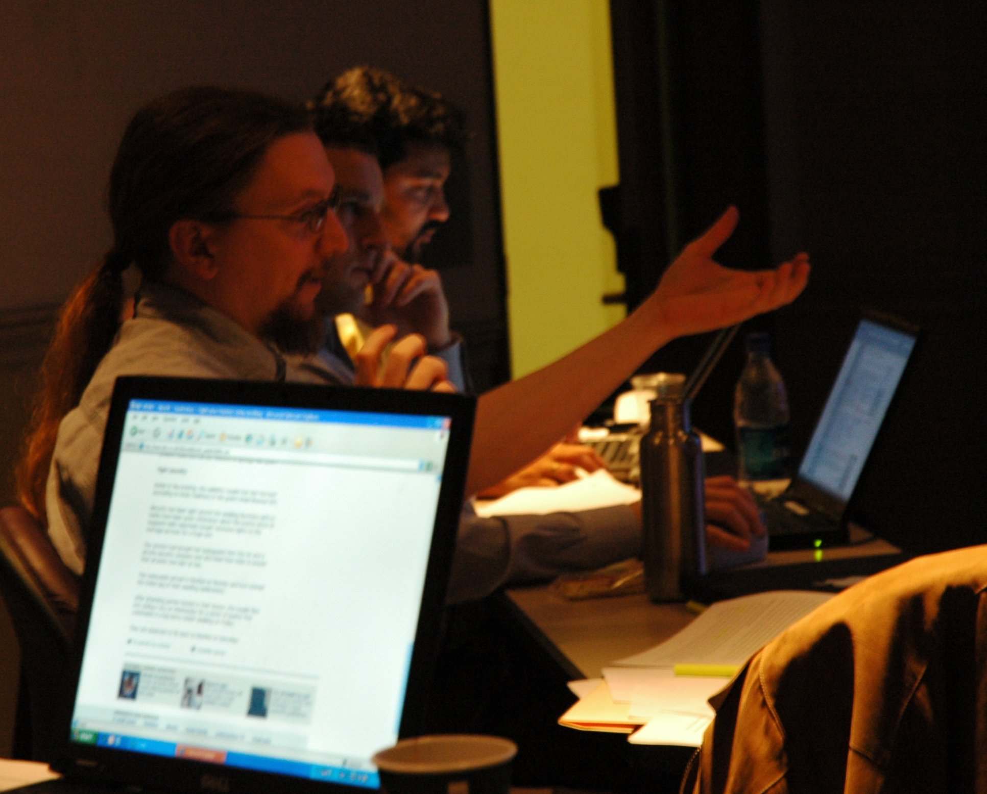 people sitting at desks in the evening with computers