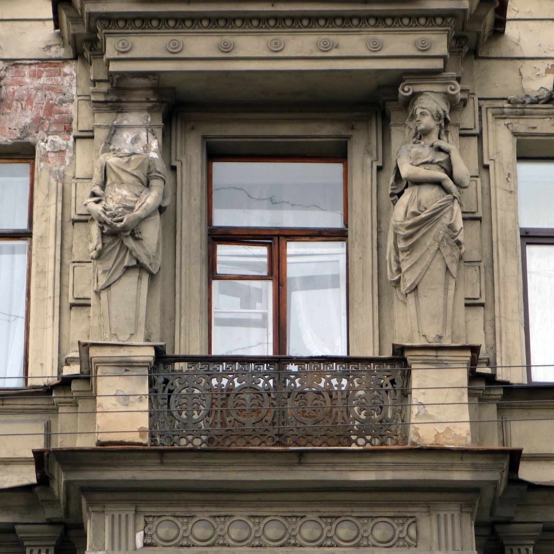 the balcony is decorated with two sculptures of women