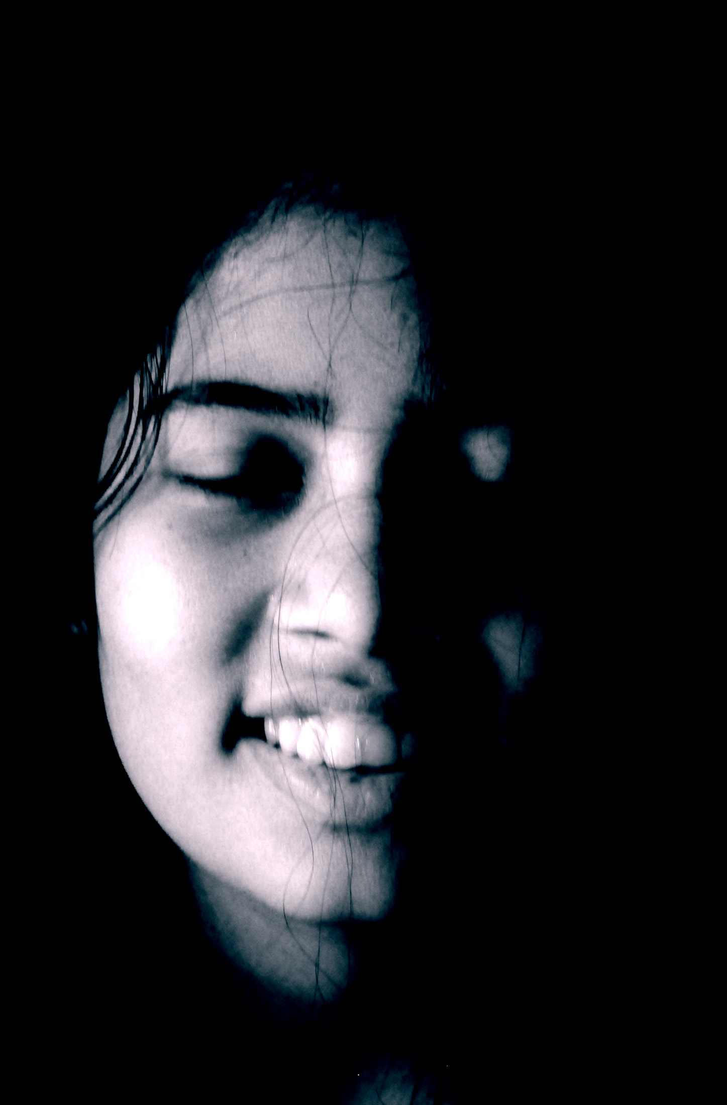 a lady smiling in the dark with her eyes closed