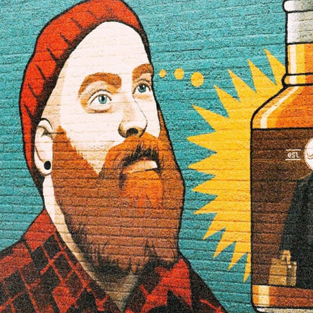 a mural of a man with a beard and wearing a red hat
