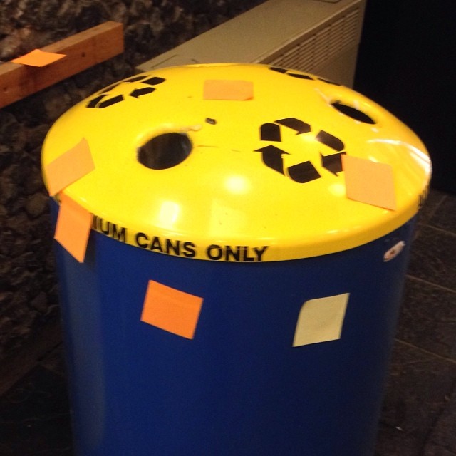 a trash can that has some papers pinned to it