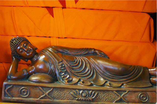 a statue laying on top of a wooden table