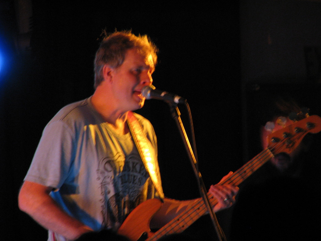 a man playing an electric guitar in front of a microphone