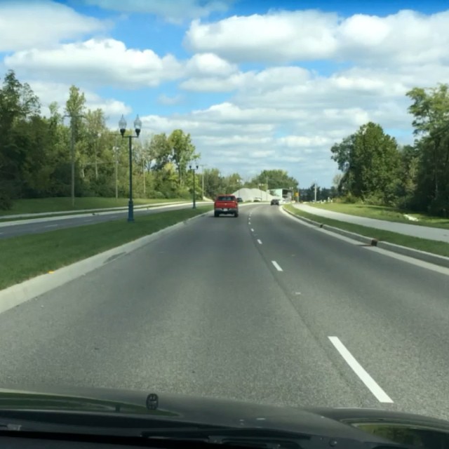 the car is driving down a highway with the view of the street
