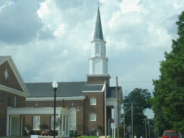 the tall church has a tall steeple and many windows