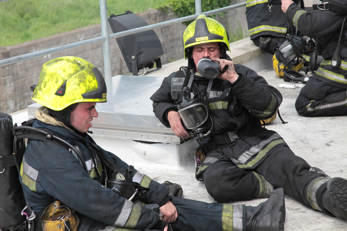 a firefighter and a man in black and yellow outfits