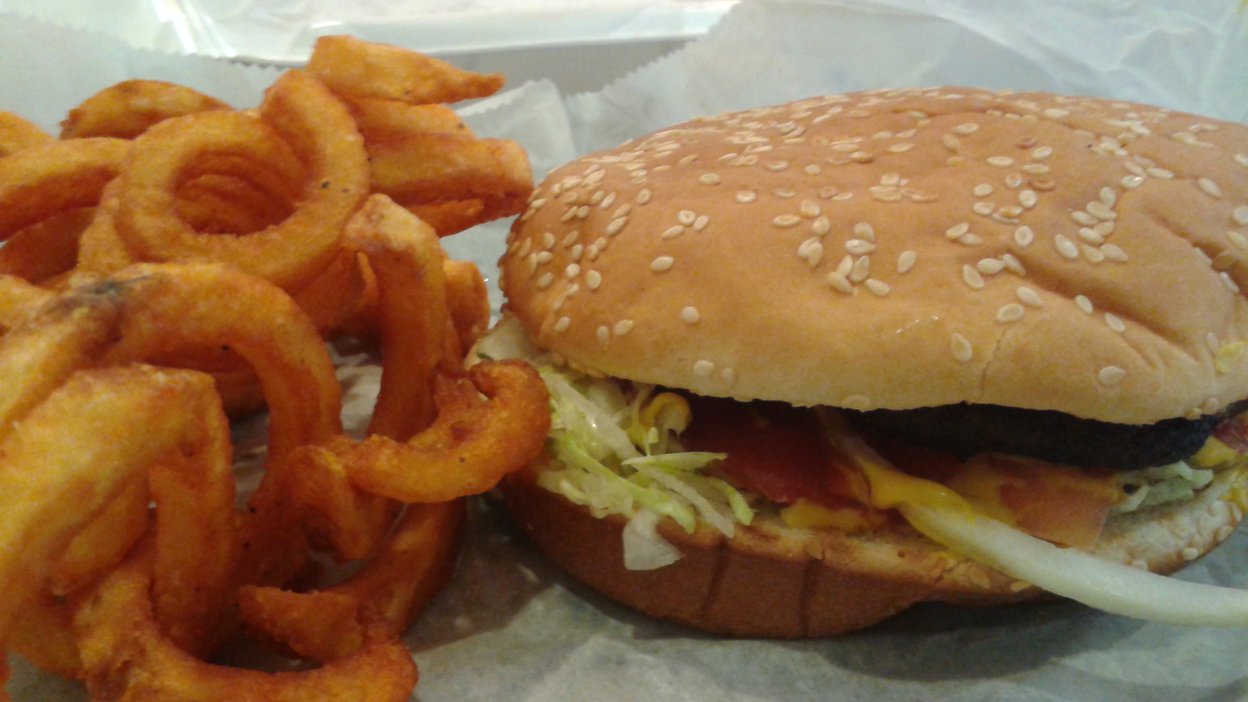 a burger and onion rings with some sauce