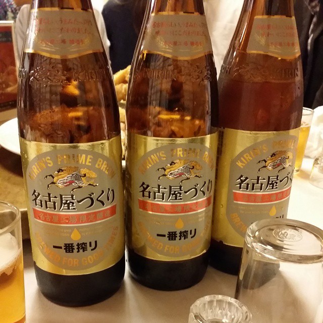 three bottles of beer on a table with several cups and utensils