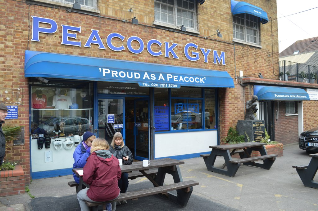 two people sitting on benches outside of a gym