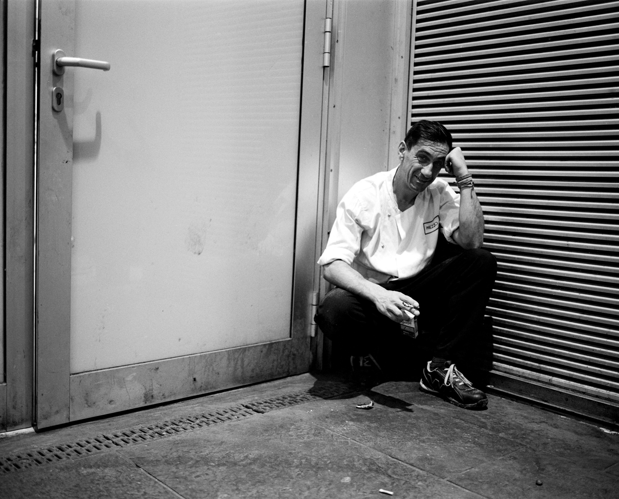 a man sitting on the ground in front of doors