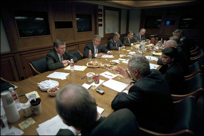 men sitting at a table having a meal in a large room