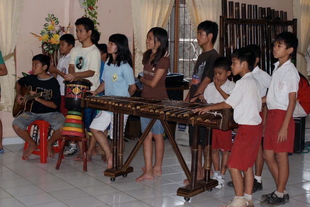 a group of children watching a man play an instrument