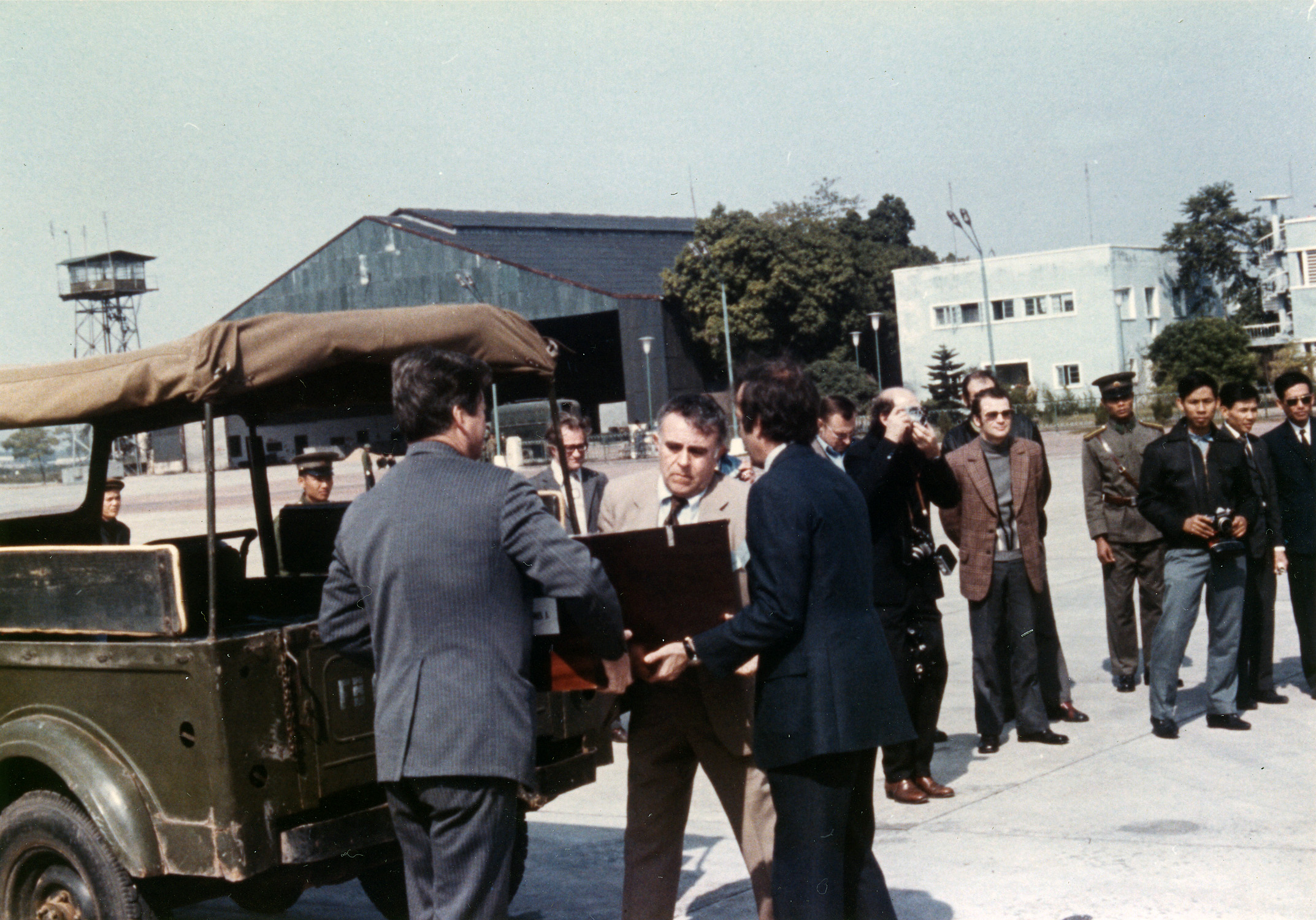 a group of men standing next to a man in a suit