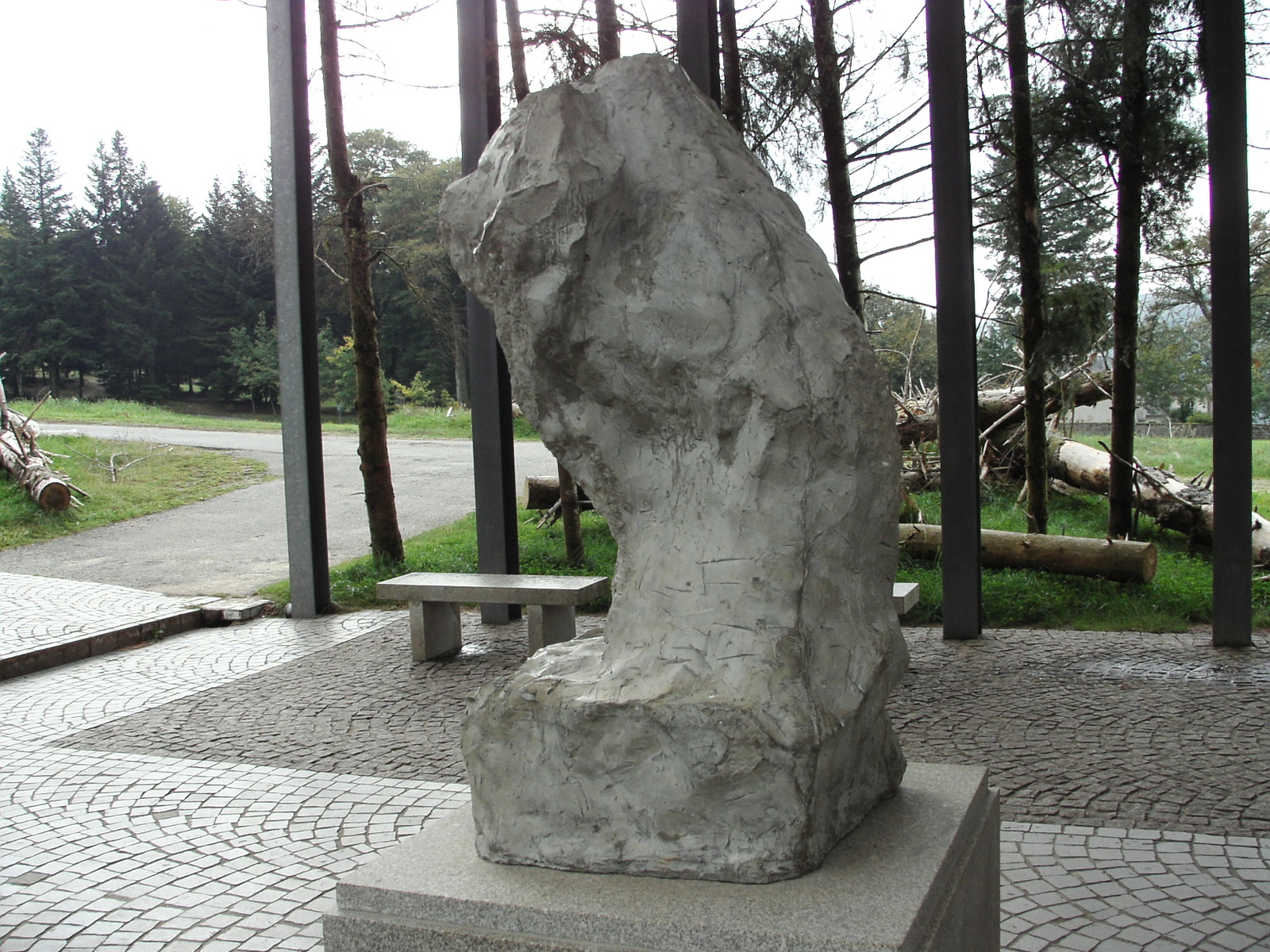 a large rock statue sitting on top of a cement bench