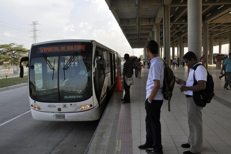 two men in uniforms are next to a bus