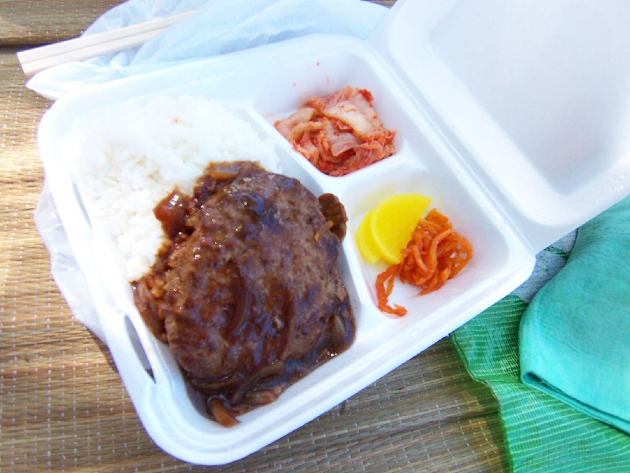 a small food tray with meat and rice