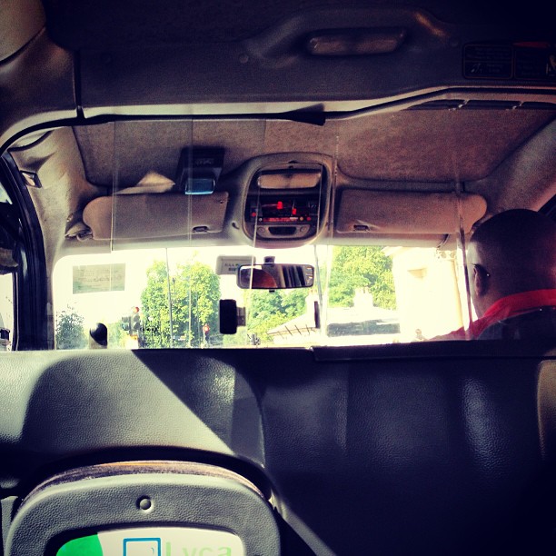 view from inside the back of a vehicle that has a person with a handbag walking out of it
