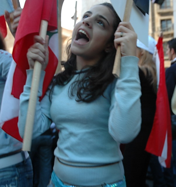 a girl holding flags as she holds an umbrella