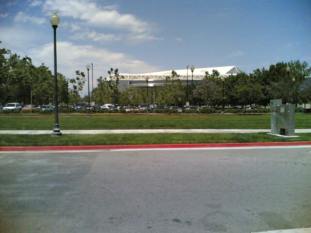 an empty parking lot with a large building in the background
