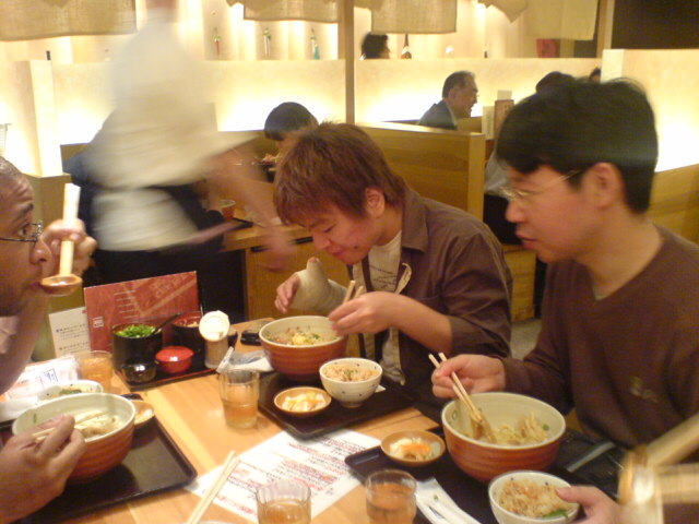 a group of people eating out of bowls on a table