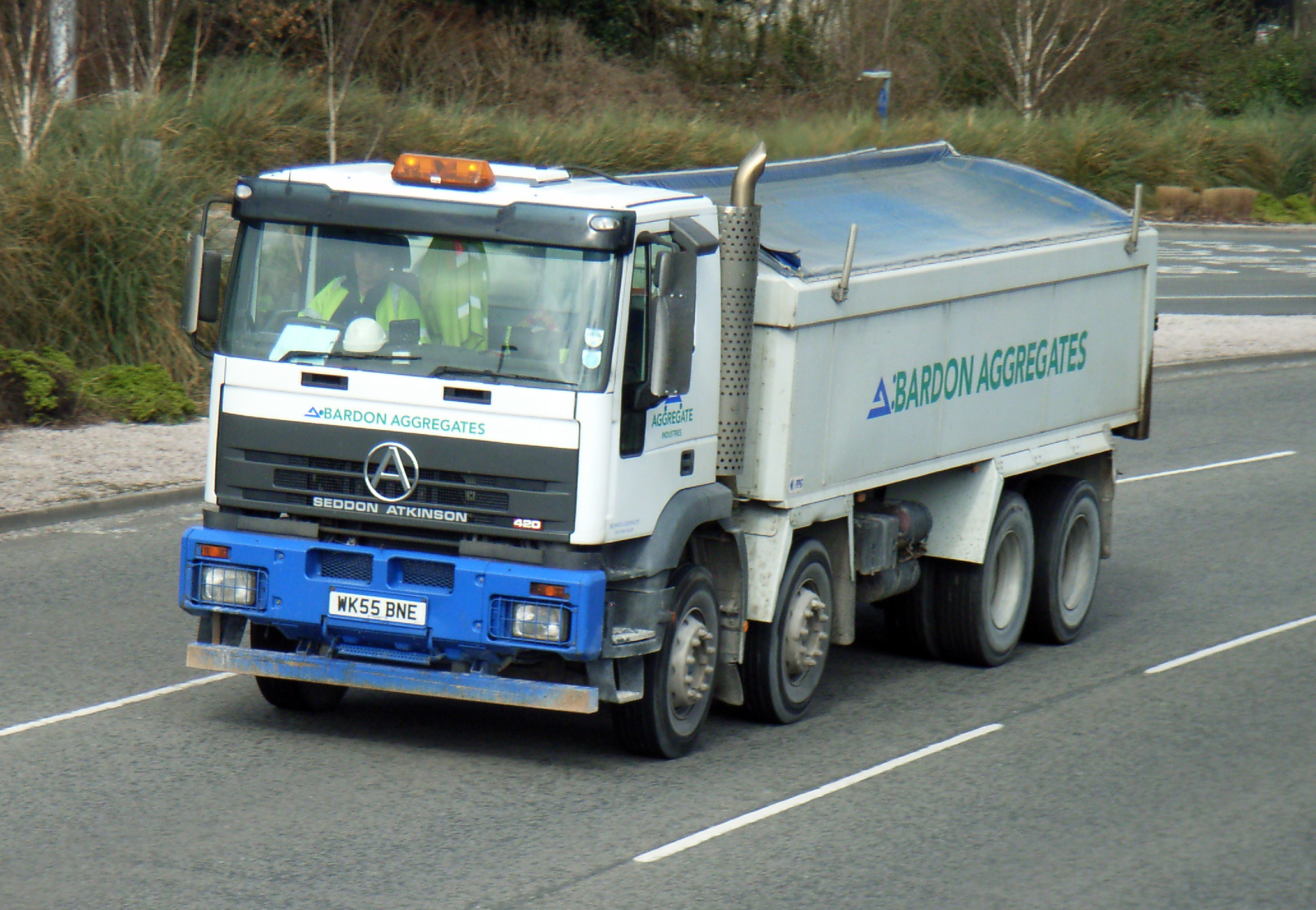 a blue and white truck is making its way along the highway