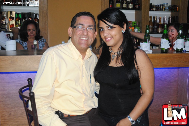 man and woman posing for pograph in front of bar counter