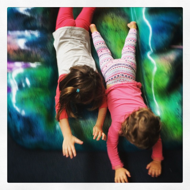 two little girls who are lying on a blanket