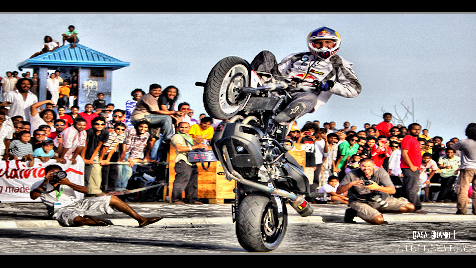 a man on a motorcycle in front of a crowd