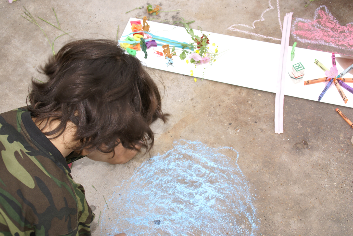 a little boy that is sitting next to a chalk board