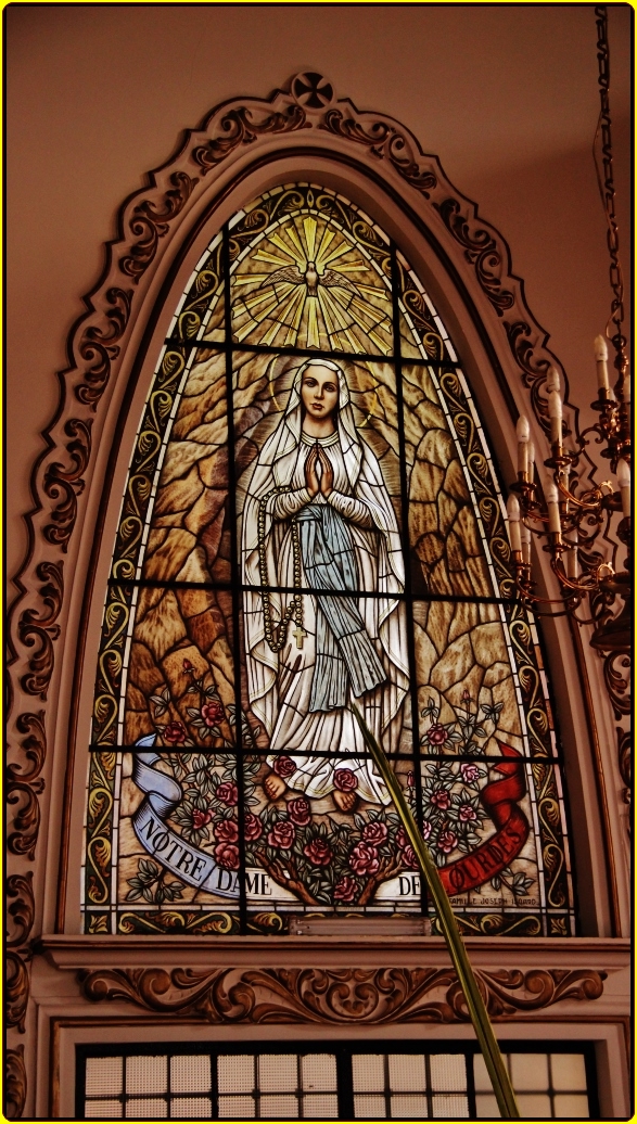 a window with a stained glass statue inside of it