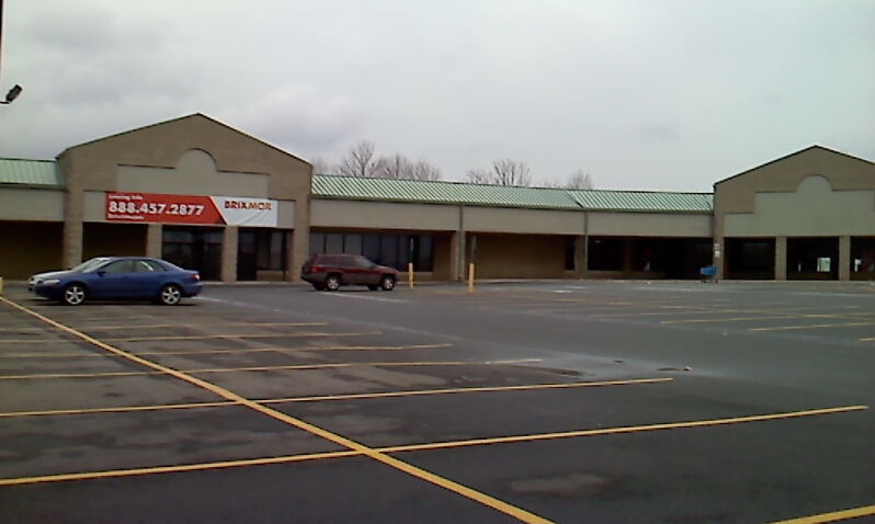 a large business with two cars parked in the parking lot