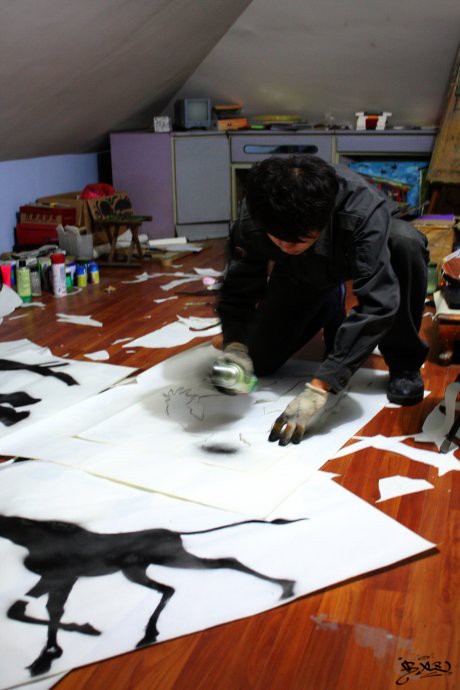 man working with black paint on white paper
