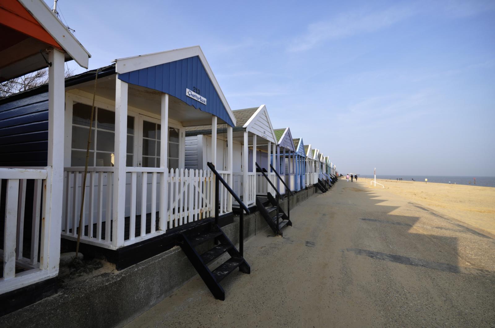 row of beach huts on a beach lined with stairs