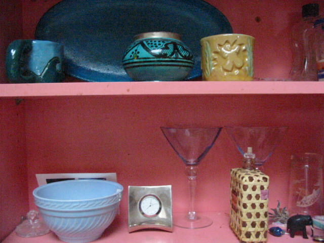 a cabinet with various items and glasses on it
