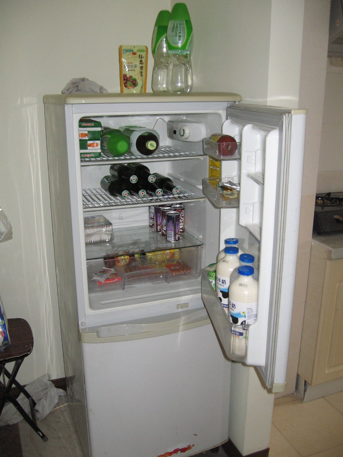 an open fridge in the corner of a kitchen